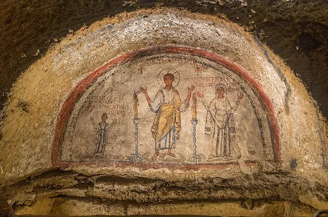 An early Christian fresco of two standing saints in an arch of the Catacombs of San Gennaro, Naples